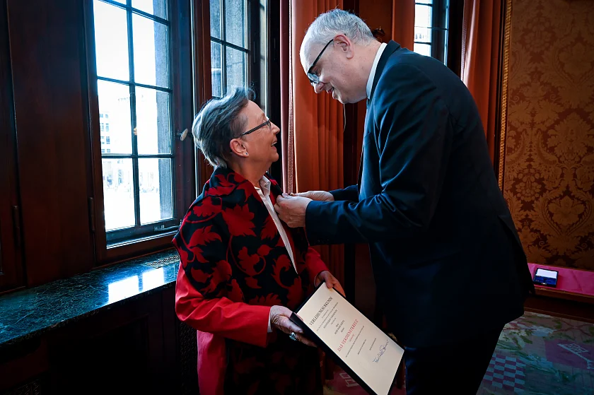 Für ihre Verdienste in der Bewahrung des Tanzes als Kulturerbe steckt Bürgermeister Bovenschulte Heide-Marie Härtel das Bundesverdienstkreuz an. Foto: Senatspressestelle