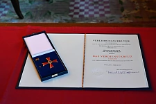 Die Verleihungsurkunde und das Verdienstkreuz 1. Klasse in Anerkennung besonderer Dienste.