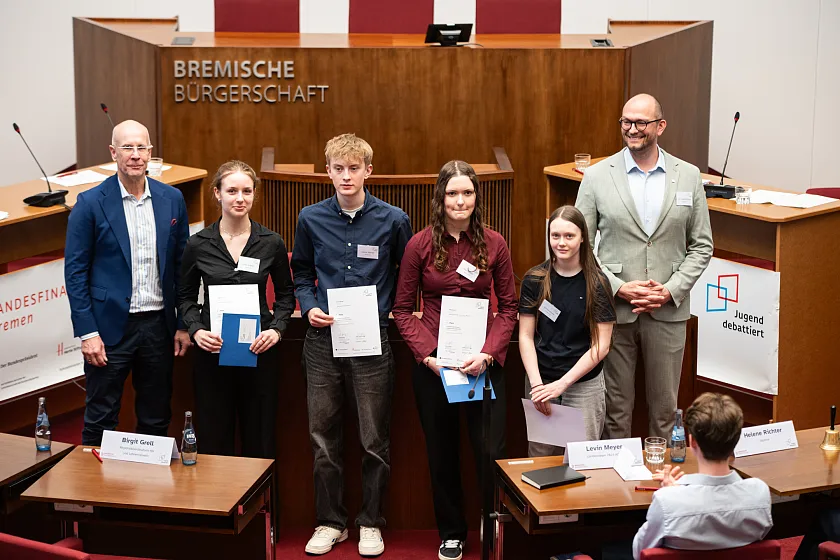 Torsten Klieme (Staatsrat Bildungsressort) gratulierte Mina Krämer (2. Platz), Jannis Sanner (3. Platz), Maya Schulz (1. Platz) und Emma Schenk (4. Platz), die in der Altersgruppe 1 (Klasse 8 bis 10) gewannen zusammen mit Dr. Jan-Jonathan Bock (Leiter Jugend debattiert, Hertie-Stiftung) (von links). Foto: Ingo Charton