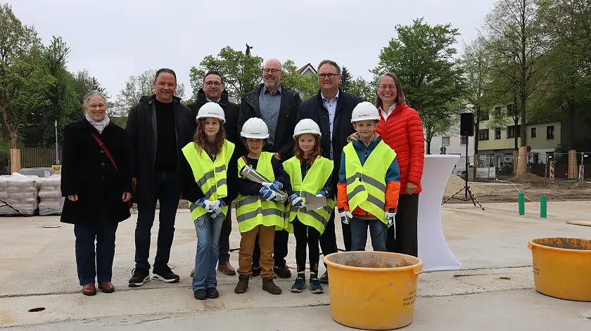v.l.n.r. Frau Sabine Leskow-Mategka und Herr Holger Franz (Immobilien Bremen), Herr Carsten Hense (Geschäftsbereichsleiter Goldbeck), Herr Sebastian Gerber (Schulleiter Alter Postweg), Finanzsenator Björn Fecker und Senatorin für Kinder und Bildung Sascha Aulepp zusammen mit SchülerInnen der Schule am Alten Postweg bei der Grundsteinlegung des Neubaus. 