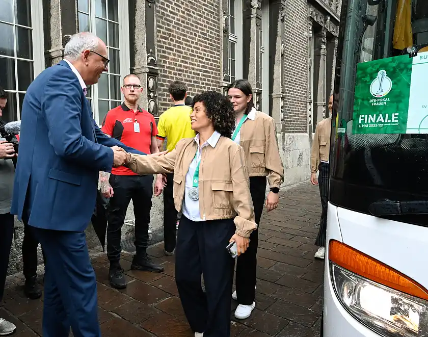 Bürgermeister Andreas Bovenschulte begrüßt die Werder-Spielerin Amira  Arfaoui vor dem Rathaus.