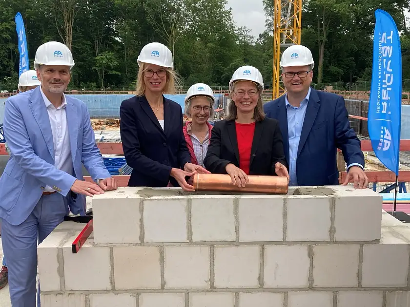 Haben bei der Grundsteinlegung für den Erweiterungsbau der Oberschule im Park die Zeitkapsel ins Mauerwerk gelegt (v.l.): Alexander Hamacher, stellv. Vorsitzender der Hegemann-Reiners-Gruppe, Schulleiterin Monika Steinhauer, Uta Kummer, Geschäftsführerin von Immobilien Bremen, Bildungssenatorin Sascha Karolin Aulepp und Finanzsenator Björn Fecker.