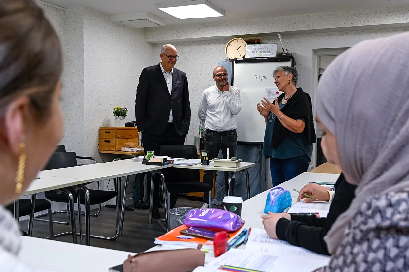 Bürgermeister Andreas Bovenschulte mit Ömer Kaya (Quartiersmanagement Lüssum) und Ute Bullert im A1-Deutschkurs für Frauen im Waschtreff Lüssum.