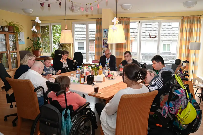 Bürgermeister Andreas Bovenschulte im Gespräch mit Bewohnerinnen und Bewohnern sowie Betreuungspersonal der Wohngruppe Feuerwache. 