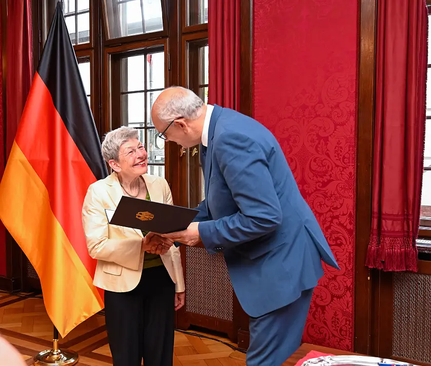 Bürgermeister Andreas Bovenschulte übergibt Regina Heygster die Verleihungsurkunde.