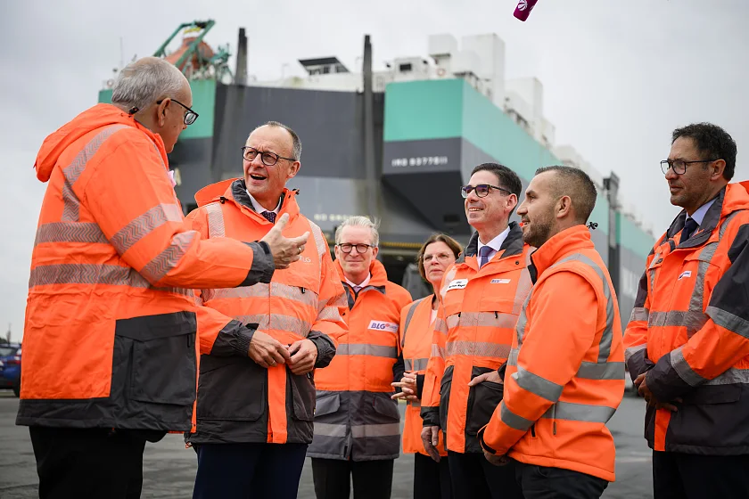 Bürgermeister Andreas Bovenschulte (links) und Bundeskanzler Friedrich Merz (2. von links) im Gespräch mit Beschäftigten der BLG. 