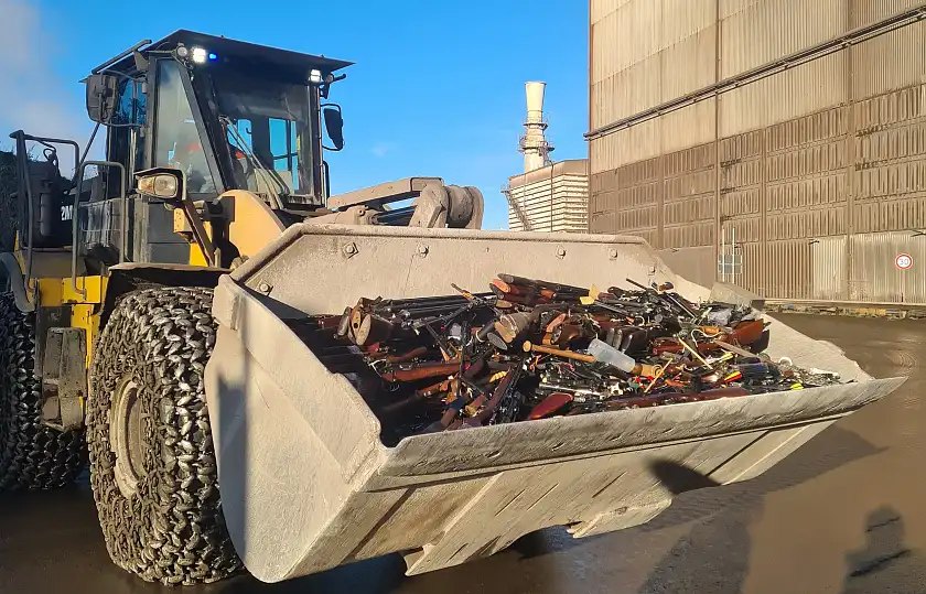 Ein Schaufelrad-Bagger voller abgegebener und beschlagnahmter Waffen wanderten in den Hochofen. 
