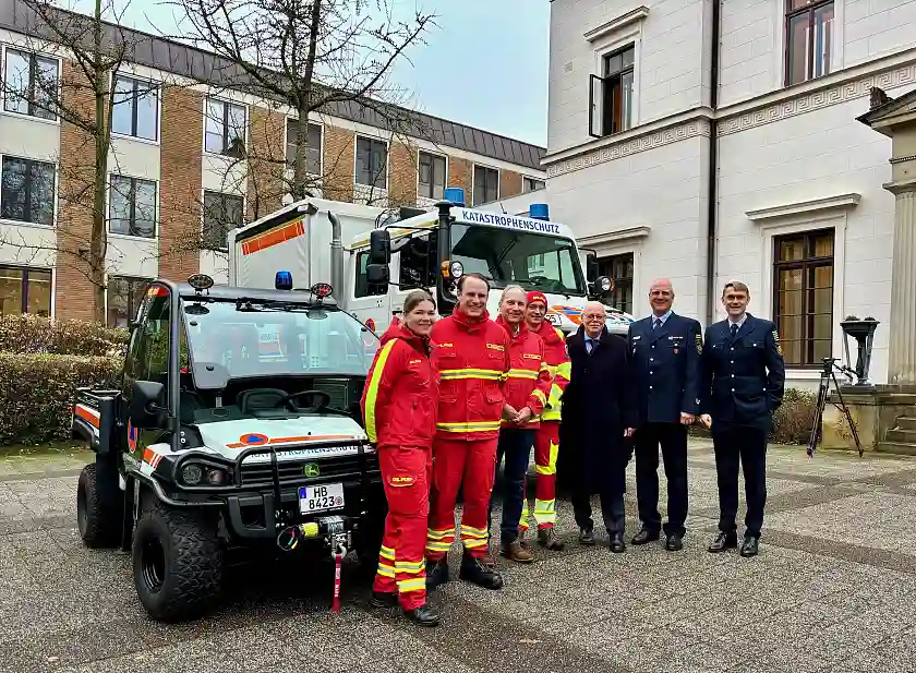 Innensenator Ulrich Mäurer (3. v. r.) mit Beschäftigten von Feuerwehr und DLRG mit den beiden neuen Fahrzeugen. 