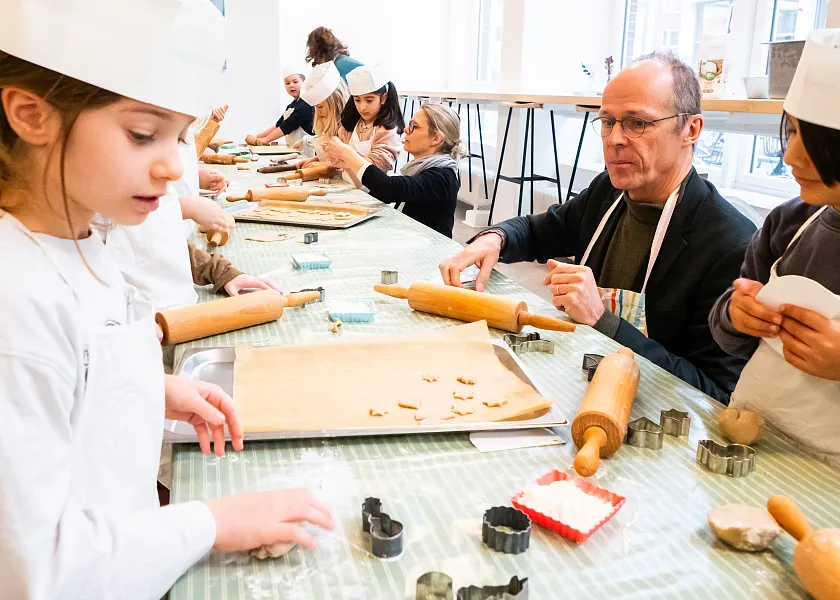 Beim Backvormittag in der BioBackstube kneten die Kinder gemeinsam mit dem Kinder- und Bildungssenator Mark Rackles konzentriert den Teig. 