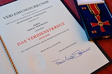 Urkunde und Bundesverdienstkreuz. 