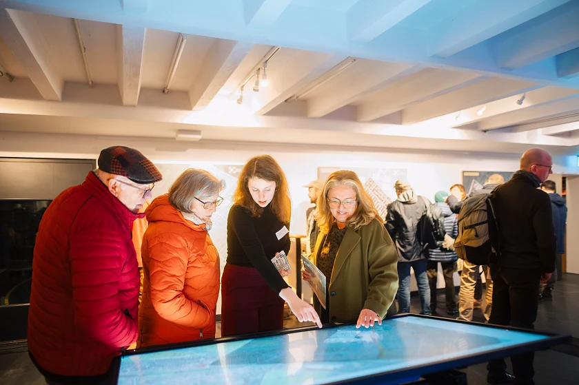 Senatorin Özlem Ünsal im Gespräch mit Bürgerinnen und Bürgern: Am interaktiven Stadtplan erläutert sie gemeinsam mit Mitarbeitenden das geplante Parkraummanagement in der Neustadt. 