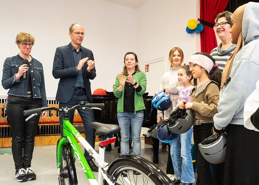 Senator Mark Rackles und Verena Nölle vom Verein Aber sicher! übergeben Preise an Kinder, die aufs Eltern- Taxi verzichten.