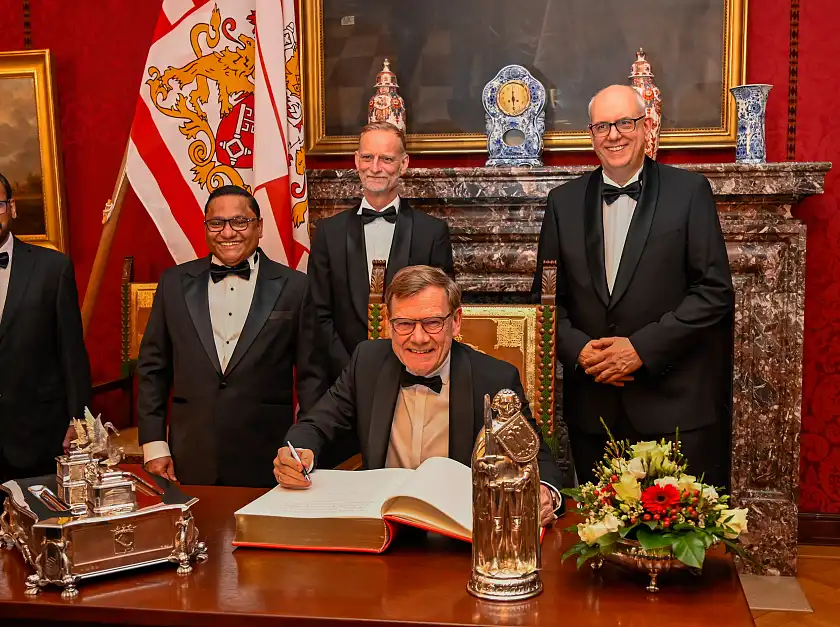 Bundesaußenminister Johann Wadephul (sitzend) und sein Amtskollege aus Sri Lanka, Vijitha Herath, (links) trugen sich vor dem Fest in das Goldene Buche Bremens ein. Mit dabei: Bürgermeister Andreas Bovenschulte (rechts) und der Vorsitzende des Ostasiatischen Vereins, Thomas Kriwat.