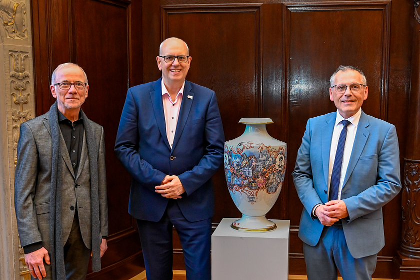 Benjamin Schäfer (Geschäftsführer Deutsche Märchenstraße), Bürgermeister Andreas Bovenschulte und Andreas Siebert (Vorstand Deutsche Märchenstraße, von links) mit der Märchenstraßen-Vase zu Beginn der Feier. 