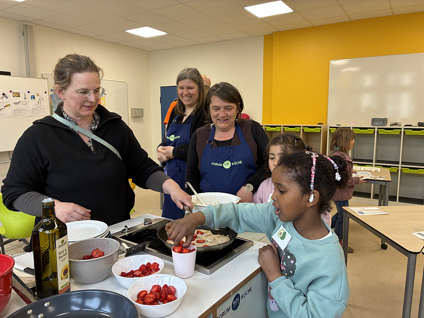 Gemeinsam mit Kindern der Grundschule Delmestraße beim Kochen am mobilen Küchenwagen (von links): Lehrerin Anne Rösemeier, Anne Bockelmann (Leiterin Forum Küche) und Senatorin Henrike Müller. 
