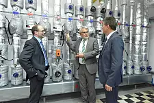 AOK Vorstand Olaf Woggan erläutert Umweltsenator Dr. Joachim Lohse und Werkstatt Bremen Geschäftsführer Ahlrich Weiberg die Klimaschutzmaßnahmen in der Steuerungszentrale.