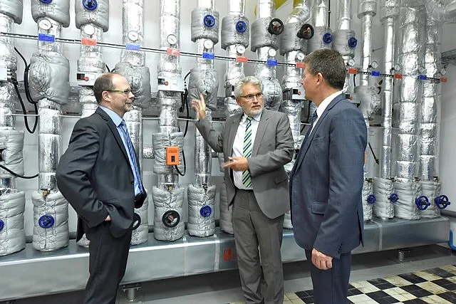 AOK Vorstand Olaf Woggan erläutert Umweltsenator Dr. Joachim Lohse und Werkstatt Bremen Geschäftsführer Ahlrich Weiberg die Klimaschutzmaßnahmen in der Steuerungszentrale.