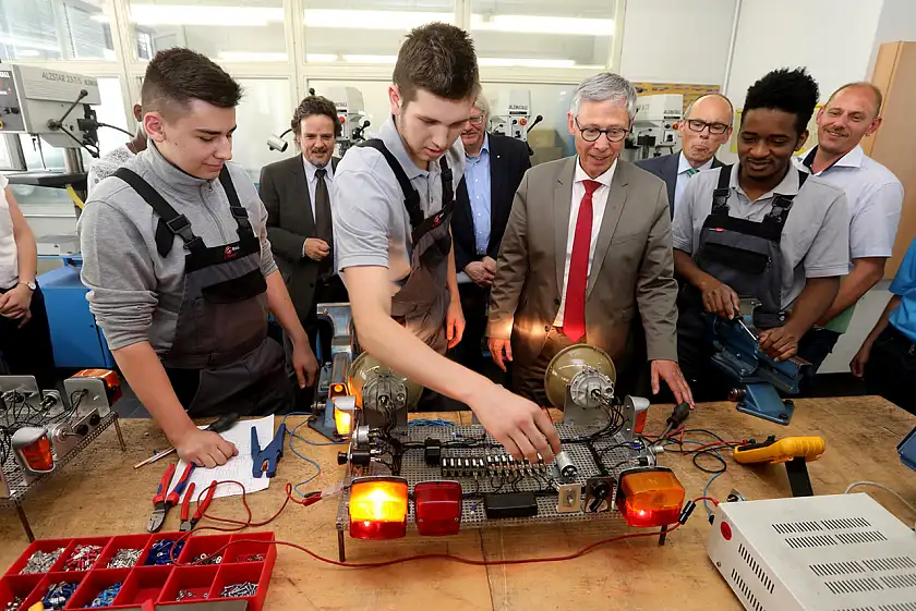 Beim Besuch der BSAG-Ausbildungswerkstatt stand Carsten Sieling wortwörtlich im Scheinwerferlicht. Die Azubis der BSAG zeigten ihm an einem Modell, wie die Busbeleuchtung funktioniert.